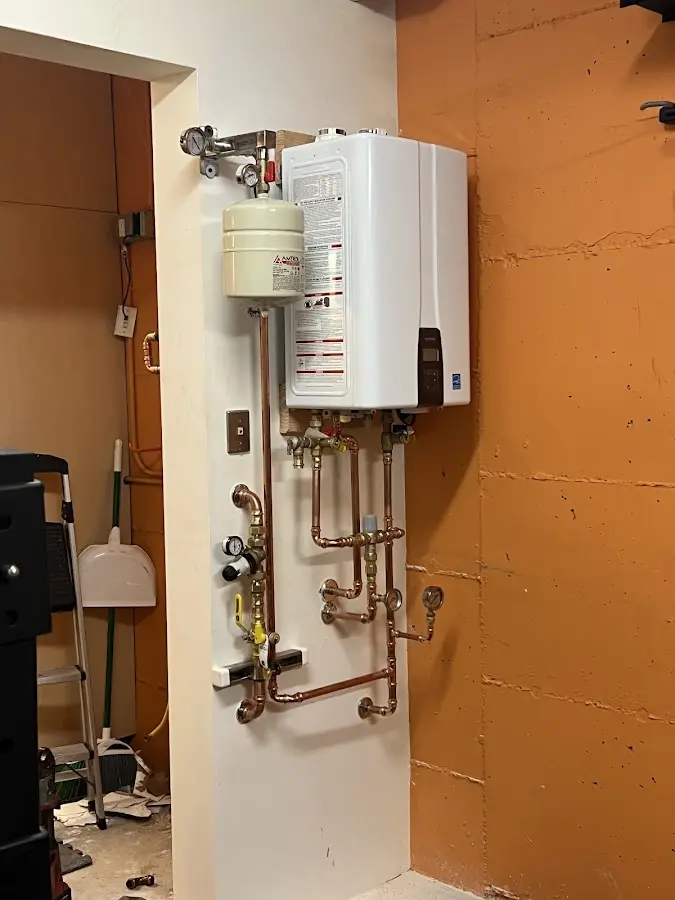 Plumbing technician inspecting water heater connections in Ventnor City